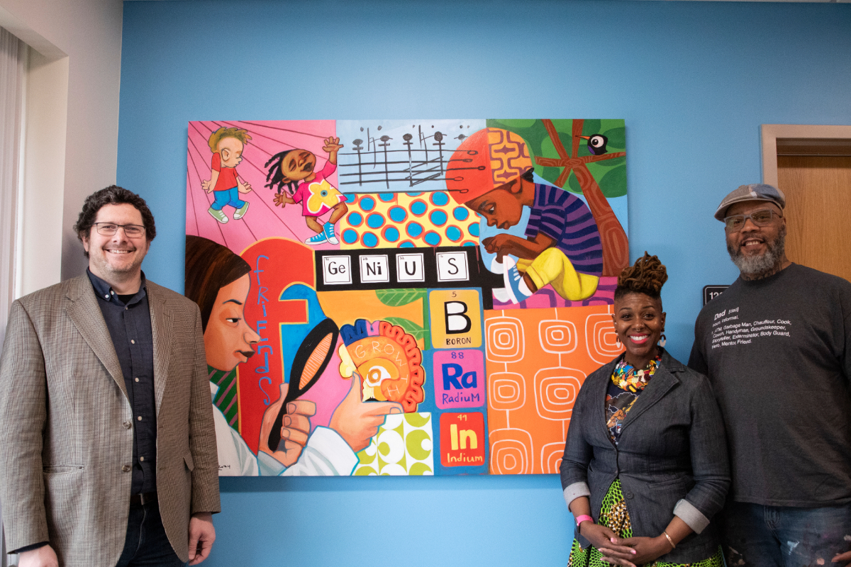 The artist cbabi bayoc stands in front of the mural with center director Adam T. Eggebrecht
